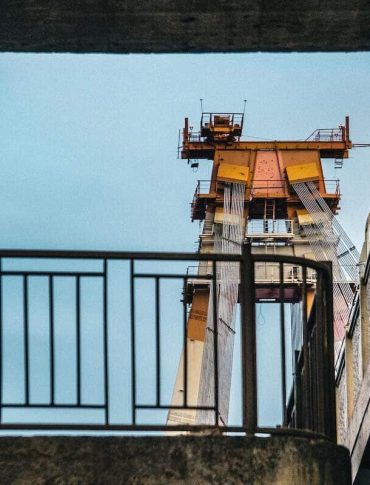 View of a large industrial crane seen from below at a shipyard.