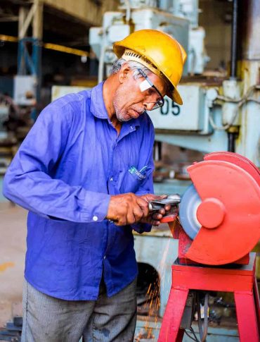 Nordast engineer inspecting machinery with grinder in workshop.
